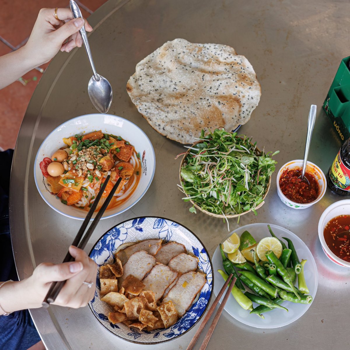 A Hoi An-style meal at Muoi, where Mi Quang, Cao Lau, fresh herbs, and rice crackers create a memorable rustic experience