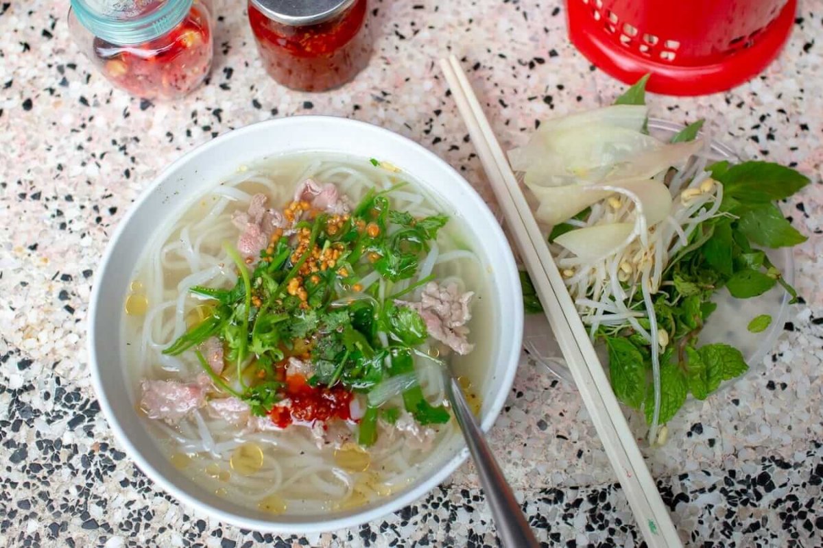 A hot bowl at Pho Ngan Hoi An with clear broth, tender beef, and fresh herbs